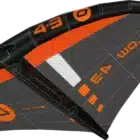 Close-up of an orange-and-black hydrofoil board/deck with stitched panels and branding visible on a gray deck surface.